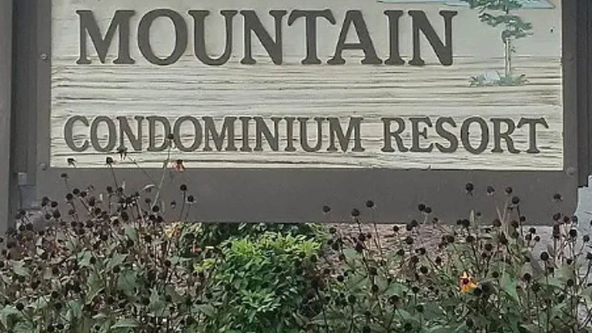 This image features clear signage for the property, surrounded by lush flora. The setting is inviting, indicating the start of the guest experience as they arrive and park, and underscoring the sense of easy access and welcome.